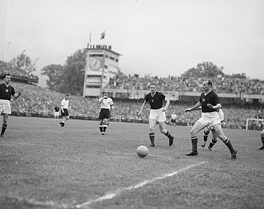 4. Minute: Buzánszky sichert den Ball vor dem hinter ihm heranstürmenden Schäfer und spielt das Leder zu seinem Torhüter zurück. Im Bild von links nach rechts: Zakariás (U), Puskás (U, hinten), Fritz Walter (D), Max Morlock (D), Lóránt (U), Jupp Posipal (D, hinten), Buzánszky (U), Hans Schäfer (D, verdeckt von Buzánszky).
