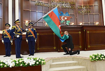 İlham Aliyev, Azerbaycan bayrağını öpüyor