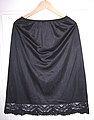 A black Vassarette vintage half slip with lace trim at the hem