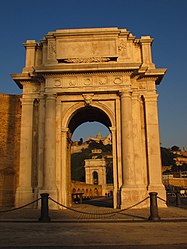 L'arco Clementino, di Luigi Vanvitelli; sullo sfondo, l'Arco di Traiano e il Duomo.