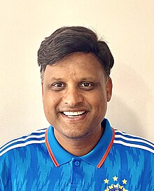 Head and shoulder photo of Manish Maheshwari in blue collared t-shirt