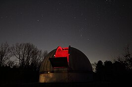 Foto van de open koepel van sterrenwacht copernicus, met in de achtergrond het sterrenbeeld Orion