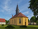 Dorfkirche und Grabmal mit Vasenaufsatz, auf dem Friedhof