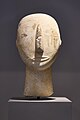Kiklad heykelinin başı. Oyulmuş burun, ağız ve kulaklar. Sağ yanakta boyalı gözler ve kırmızı dikey çizgiler mevcut. Parian; Amorgos'ta bulunmuştur. (Erken Kiklad II dönemi, MÖ 2800-2300, Keros-Syros kültürü. Atina Ulusal Arkeoloji Müzesi.)