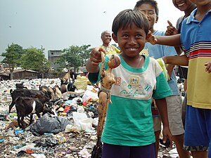 A boy from an East Cipinang trash dump slum shows his find, Jakarta Indonesia.