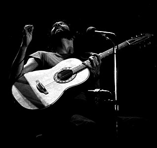 1976'da, Almanya'da gerçekleşen bir konseri sırasında Cat Stevens. Aynı yıl yaşadığı bir kaza sonrasında ruhani arayışına odaklanmış, 1977 yılında Müslüman olmuş ve 1978 yılında ismini Yusuf İslam olarak değiştirmiştir.(Üreten:William McElligott)