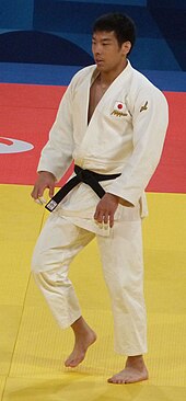 Takanori Nagase steht im weißen Judogi auf der Matte.