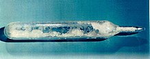 test-tube like glass container, with pointy sealed end, filled with white crystals