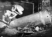 Men disarming a dud mortar shell in the Café Adria basement