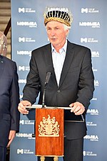 Elderly man standing at podium microphone