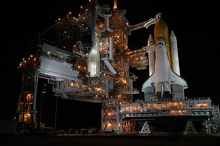 Discovery Uzay Mekiği'nin STS-114 için tahmin edilen kalkış tarihinden bir gün önce çekilmiş bir fotoğrafı. 13 Haziran 2005 günü kalkması beklenen STS-114, yakıt tankında ortaya çıkan aksaklıklardan dolayı ancak 26 Haziran 2005 günü kalkabilmişti. STS-114 7 kişilik mürettebatı ile 9 Ağustos 2005 günü dünyaya döndü.(Üreten:NASA)