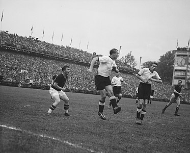 75. Minute: Posipal klärt einen ungarischen Angriff mit Kopfballabwehr vor dem lauernden Stürmer und Spielführer Puskás. Im Bild von links nach rechts: Kocsis (U, hinter Puskás), Puskás (U), Jupp Posipal (D), Karl Mai (D, hinter Posipal), Horst Eckel (D), Hidegkuti (U)