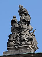 40. Trophäe – Baumstamm, Turban, Harnische mit Helm, Fass, Vasen, Lanzenfahne.