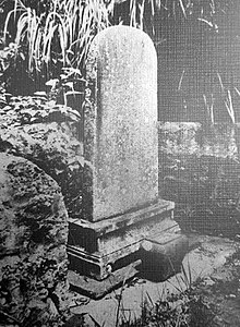 A black and white photo of a stele on a pedestal