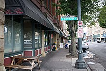 Photograph showing the sidewalk and a picnic table outside the bar