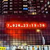 Auf einer Hauswand leuchtet nachts rot ein digitaler Countdown, der bei 7 Jahren, 20 Tagen, 23 Stunden, 19 Minuten und 30 Sekunden steht