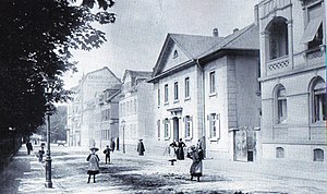 Kurfürstenstraße 4 bis 22. Ganz rechts Nr. 4, daneben das kurhessische Amthaus, Nr. 6. Das zweitletzte Haus im Bild, Nr. 20, ein Mehrfamilienhaus mit Wandreklame der Firma Ratazzi & May (im Hinterhof) am hohen Giebel. Das letzte Gebäude, neben Nr. 22, die Ecke zur Großen Seestraße mit der Stern-Apotheke. Hinter dem Ende der Straße der Kurfürstenplatz mit Teilen des Brunnenfundamentes. (1905)