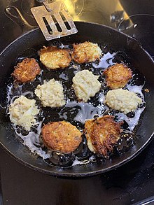 Potato latkes frying in a skillet