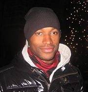 A man is wearing a coat and a beanie.