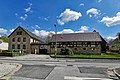 Wohnstallhaus, Seitengebäude und Toreinfahrt mit Holztor und seitlichem Durchgang eines Vierseithofes