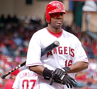 A baseball player wearing a uniform inscribed with the word "Atlanta" has swung a baseball bat and is running. The catcher is partially visible.