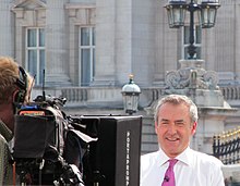 Sky News journalist Colin Brazier speaking to a camera in front of Buckingham Palace, London, UK