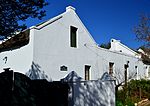 4 attached vernacular cottages, straight end gables with parapets except for cottage 2nd from left which has flat roof behind stepped up parapet with simple moulded detail. Windows are 3 × 2 sliding sashes, doors have 3-pane fanlights over. Cement stoep Type of site: House Current use: Residential. This interesting architectural group of buildings consists of four attached houses in the vernacular style. The oldest part is about 100 years old. The other parts were added from time to time according to the needs of the owners.