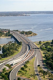 A highway and railway bridge crossing a river viewed from a skyscraper