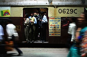 Commuters in an open train door at Churchgate Station in Mumbai
