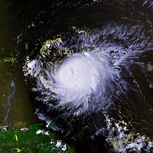 Multicolored satellite image of hurricane, with a clear eye at its center.