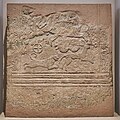 Poros taşından yapılmış, araba ve av sahnesi kabartmalı Miken mezar steli. Ana panel, iki atın (diphro) çektiği ve ayakta duran bir arabacının kullandığı bir arabayı göstermektedir. Alt panelde bir geyiğin üzerine saldıran bir aslan tasvir edilmiştir. (MÖ 16. yüzyıl. Atina Ulusal Arkeoloji Müzesi.)