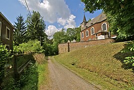 Photograph of a village, with a road in the middle and a church on the right.