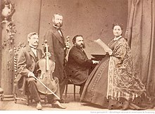 Carlo Alfredo Piatti sitting with his cello, Henri Vieuxtemps holding his violin, Alfred Jaëll sitting at his piano, and Patti standing while holding music sheets