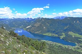 A body of water flowing through a valley, surrounded by highlands and mountain ranges.