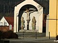 Vor der Kirche, mittelalterlicher Christus im Bildstock