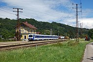 Ein 4020-Triebwagen mit dem Bahnhofsgebäude von Viehofen im Hintergrund.