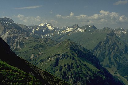 The Giebel (mountain with triangular, partly wooded flank, far right) from the northwestern arête of the Älpelekopf. The grassy mountain front centre is the Roßkopf. High right in the background is the Schneck. Far left is the Glasfelderkopf. Opposite the Schneck is the Großer Wilder and the snow-filled Gamswanne. Between the Schneck and the Großer Wilder is the Himmelecksattel.