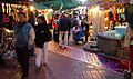 Photo of Olvera Street with enhancement of the brickwork showing the course of the Zanja Madre through the pueblo. The fountain next to the brickwork was constructed by Christine Sterling "in memory of this very important stream of water which gave life to the growing things of the pueblo”.[13]