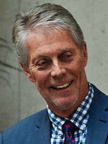 Eisenberger smiling and wearing a blue suit.