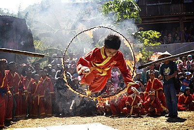 Seorang murid pencak silat tengah meloncat melewati lingkaran api