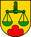 Gemeinde Scharten In Gold über einem roten Dreiberg eine grüne Balkenwaage mit Aufhängehaken und gleichstehenden Schalen.