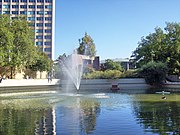 Im Vordergrund der Springbrunnen, links dahinter der Phil-Turm, in der Mitte die Tribüne und rechts eine Teilansicht vom Audimax