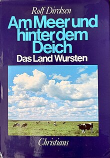 Neben dem Titel des Buches und seinem Autor ist ein Foto mit grünem Weideland und schwarz-weißen Küchen abgebildet.