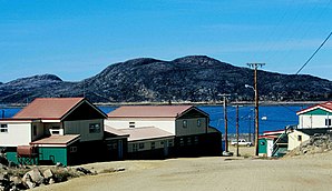 Gebäude der West Baffin Eskimo Co-operative Cape Dorset, in denen Inuit-Kunstgrafik gefertigt wird; im Hintergrund: Nachbarinsel Mallikjuaq