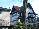 Villa mit Wirtschaftsgebäude, Garage und Bootsschuppen, Terrassenmauer im Garten und straßenseitiger Einfriedung