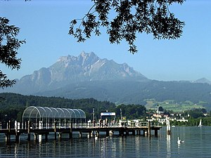 Pier jutting out into a lake with a mountain in the rear