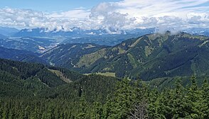 Blick vom Wetterkogel auf der Hochalpe nach Westnordwest über den Klein-Gößgraben. Links mittig das Mitteregg, an dem der Groß-Gößgraben abzweigt. Am Ausgang des Grabens die Leobener Stadtteile Göss und Leitendorf mit dem weithin sichtbaren Kalkwerk Leoben.