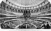 Drei amphitheatralisch zurückversetzte, aufsteigende Ränge mit einem Logenrang der Royal Albert Hall, London