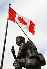 a statue of a person in front of a flag and two other persons kneeling down