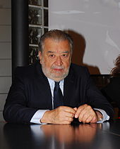 A man in a suit seated at a desk